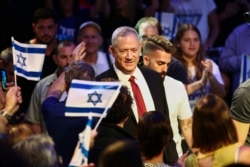 FILE - Blue and White party leader Benny Gantz gets surrounded by supporters as he arrives at a campaign event in Tel Aviv, Israel, Sept. 15, 2019.