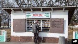 Muškarac kupuje kruh u seoskom dućanu u ukrajinskom selu Dobryanka blizu bjeloruske granice (AP Photo/Oleksandr Ratushniak)