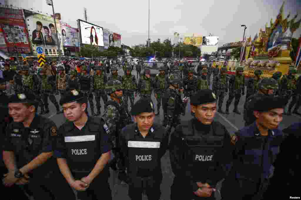 Police officers and soldiers stand guard during a protest against military rule at Victory Monument in central Bangkok, May 26, 2014. 