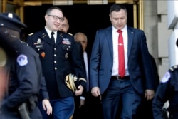 FILE - Lt. Col. Alexander Vindman, left, walks with his twin brother, Yevgeny Vindman, after testifying before the House Intelligence Committee, on Capitol Hill in Washington, Nov. 19, 2019.