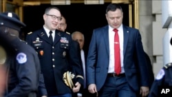 FILE - Lt. Col. Alexander Vindman, left, walks with his twin brother, Yevgeny Vindman, after testifying before the House Intelligence Committee, on Capitol Hill in Washington, Nov. 19, 2019.