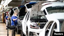 Radnici sklapaju automobile u Folksvagenovoj fabrici u Volfsburgu u Nemačkoj, 27. aprila 2020. Proizvodnja je bila zaustavljena zbog epidemije koronavirusa.