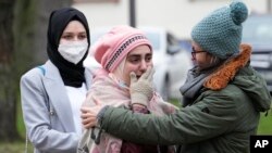 Syrian women Yasemine, center, who lost her father and brother in Syria, reacts after the verdict in front of the court in Koblenz, Germany. A German court found Anwar Raslan, a former Syrian secret police officer, guilty of crimes against humanity for overseeing the abuse of detainees at a jail near Damascus 10 years ago.