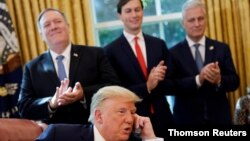 U.S. President Donald Trump is seen on the phone with leaders of Israel and Sudan in the Oval Office at the White House in Washington