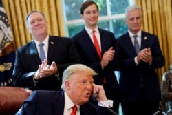 U.S. President Donald Trump is seen on the phone with leaders of Israel and Sudan in the Oval Office at the White House in Washington.