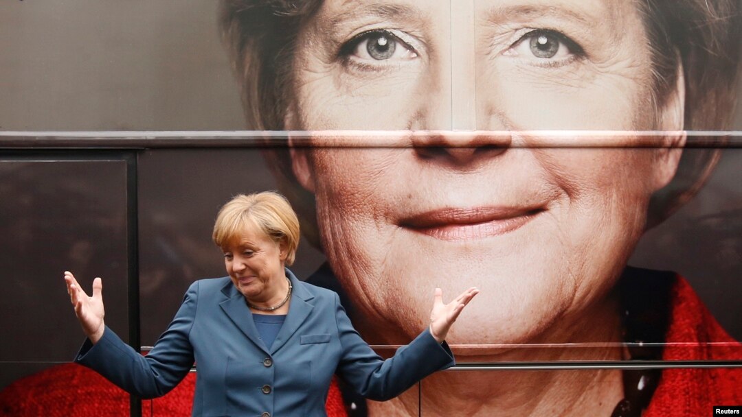 Thủ tướng Đức Angela Merkel đứng trước tấm áp phích quảng cáo cho chiến dịch tranh cử