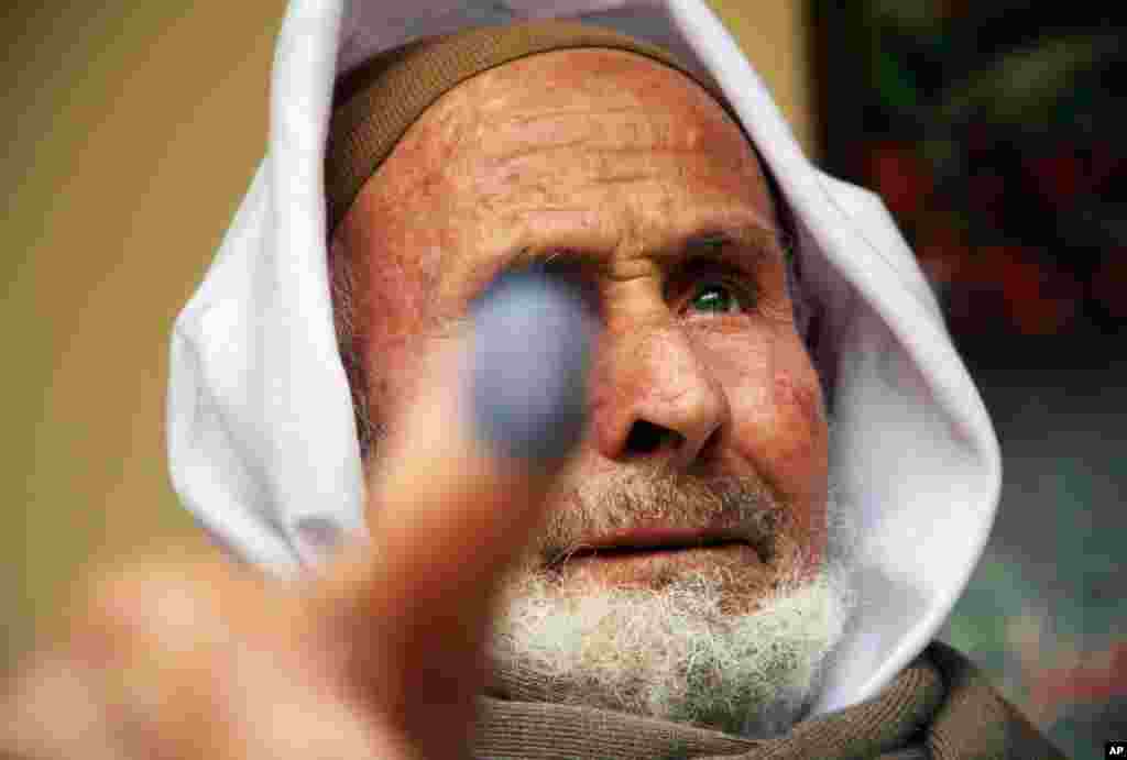 An Egyptian man shows his inked thumb after casting his vote in Menoufia, Egypt, Wednesday, Dec. 14, 2011. Egyptians turned out in large numbers Wednesday to vote in the second round of parliamentary elections that have become a stiff competition between 