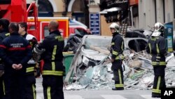 Firefighters stand on the scene of a suspected gas explosion in Paris, Jan. 13, 2019. 