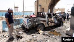 A man stands at the site of a suicide bomb attack at a checkpoint in Rashidiya, a district north of Baghdad, Iraq on July 13, 2016. 