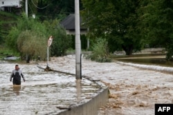 A man walks in along a flooded road following heavy rains in the town of Kiseljak, Bosnia-Herzegovina, Oct. 4, 2024.