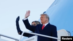 El presidente Donald Trump y su esposa, Melania Trump, se despiden antes de abordar el avión presidencial en la Base Aérea de Andrews, en Maryland, para volar rumbo a Mar-a-Lago, en la Florida, el 20 de enero de 2021.