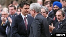 Justin Trudeau (kiri) berjabat tangan dengan mantan PM Kanada Stephen Harper di Ottawa (foto: dok).