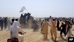 Para pendukung Taliban mebawa bendera khas Taliban berwarna putih di wilayah perbatasan antara Afghanistan dan Pakistan di Kota Chaman, pada 14 Juli 2021. (Foto: AP/Tariq Achkzai)