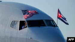 FILE - An American Airlines plane fluttering U.S. and Cuba national flags arrives at Jose Marti International Airport in Havana, Nov. 28, 2016.