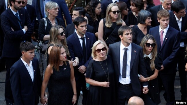 Los dolientes observan cómo el ataúd que contiene el cuerpo del ex presidente de Chile, Sebastián Piñera, sale del antiguo edificio del Congreso Nacional para su funeral en Santiago, Chile, el 9 de febrero de 2024.