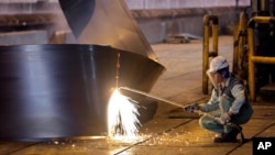 FILE - A worker cuts a steel roll at the Mobarakeh Steel Complex, some 460 kilometers south of Iran's capital Tehran, May 31, 2012.