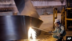 FILE - A worker cuts a steel roll at the Mobarakeh Steel Complex, some 460 kilometers south of Iran's capital Tehran, May 31, 2012.