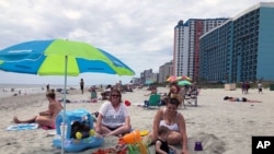 FILE - Vacationers from Ohio enjoy a day at the beach, in Myrtle Beach, South Carolina, June 18, 2020.