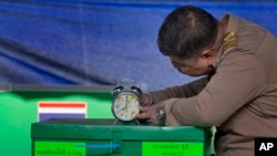 A Thai officer checks a clock to commence voting at a polling station in Bangkok, Thailand, March 24, 2019. Thailand's first general election since the military seized power in a 2014 coup has begun.