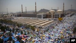 Muslim pilgrims hold umbrellas as they attend noon prayers outside the Namirah mosque on Arafat Mountain, during the annual Hajj pilgrimage, outside the holy city of Mecca, Saudi Arabia, Aug. 31, 2017.