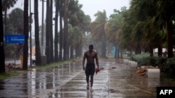 A man walks under pouring rain during Tropical Storm Isaias in Santo Domingo, Dominican Republic, on July 30, 2020. 