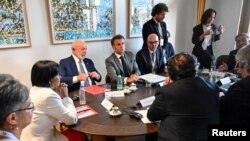 El presidente de Francia, Emmanuel Macron, lidera una reunión sobre el diálogo en Venezuela junto a 3 mandatarios latinoamericanos y delegados del gobierno de Nicolás Maduro y la oposición, en los extremos de la foto, en Bruselas, Bélgica.