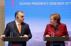 FILE - German Chancellor Angela Merkel speaks to Hungarian Prime Minister Viktor Orban during a news conference in Bratislava, Slovakia, Feb. 7, 2019.