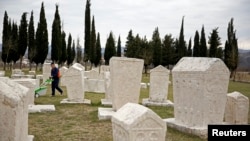 A worker cuts grass at Radimlja necropolis near Stolac, March 10, 2015. The tombstones date to the 12th century and are revered in the Balkans for their unique decorative symbols and carvings, often linked to the medieval Kingdom of Bosnia.
