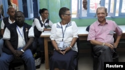 FILE - Seychelles President James Michel, right, talks to lawyer Alexia Antao at a voting center during the presidential polls in Victoria, Seychelles, Dec. 3, 2015. 