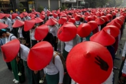 FILE - Anti-coup school teachers in their uniform and traditional Myanmar-hats participate in a demonstration in Mandalay, Myanmar, March 3, 2021. D