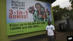 A man walk past a giant advertisement bill board of Nigeria Globacom in Lagos, May, 13. 2012.