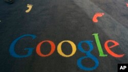 FILE - The Google logo is printed on the carpet during the inauguration of the new Google cultural institute in Paris, Dec. 10, 2013.