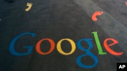 FILE - The Google logo is printed on the carpet during the inauguration of the Google cultural institute in Paris, Dec. 10, 2013.