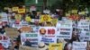 Anti-coup protesters display placards near the Indonesian Embassy in Yangon, Myanmar, Wednesday, Feb. 24, 2021. (AP Photo)