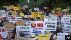 Anti-coup protesters display placards near the Indonesian Embassy in Yangon, Myanmar, Wednesday, Feb. 24, 2021. (AP Photo)