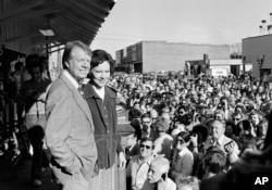 FILE - President-elect Jimmy Carter tells a group of people gathered at the Plains, Ga., train station about a congratulatory phone call he received from President Ford, Nov. 3, 1976. (AP Photo)