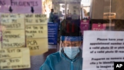 FILE - A test specialist works at a COVID-19 testing site in Los Angeles, Dec. 9, 2020. A lab in Minnesota confirmed Monday the first U.S. case associated with the variant originally seen in Brazil.