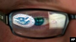 美國國土安全部門的網絡專家的眼鏡倒影該部門標誌