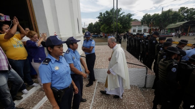 El padre Edwin Román regresa a su iglesia después de que no logró convencer a la policía de permitir que los familiares de los manifestantes antigubernamentales muertos y encarcelados ingresen a la iglesia San Miguel Arcángel en Masaya, Nicaragua, el jueves 14 de noviembre de 2019. (Foto AP/Alfredo Zúñiga)