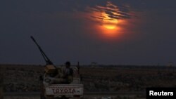 A Free Syrian army fighter sits on a pick-up truck mounted with a weapon in the west of the rebel-held town of Dael, in Deraa Governorate, Syria, Nov. 14, 2016. 