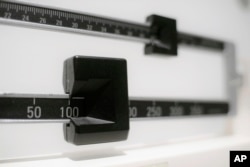 FILE - This photo shows a closeup of a beam scale in New York, April 3, 2018. Women were nearly twice as likely as men to report severe obesity, according to a 2021-2023 survey of about 6,000 people.