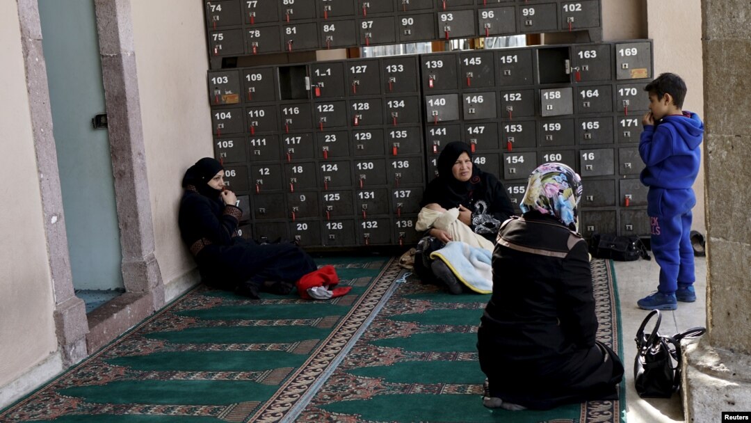 Syrian women rest at the entrance of a mosque in the neighborhood of Basmane, which is filled with transient migrants on their way to Europe, in the Aegean port city of Izmir, western Turkey, March 8, 2016. 