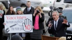 Robert Kennedy Jr., a la derecha, pronuncia un mensaje durante una manifestación en contra de una iniciativa que quitaría a los padres la autoridad de oponer razones filosóficas para impedir que a sus hijos en edad escolar les apliquen la vacuna combinada contra el sarampión.