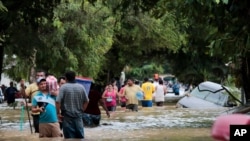 Personas caminan en las calles inundadas de Planeta, Honduras, viernes 6 de noviembre de 2020.