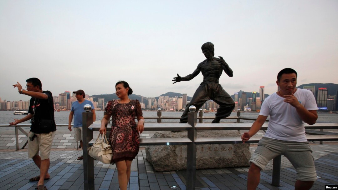 游客在香港功夫明星李小龙像前摆姿势