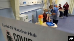 Nurse Katie McIntosh administers an injection of the Pfizer/BioNTech Covid-19 vaccine to Clinical Nurse Manager Fiona Churchill, at the Western General Hospital, in Edinburgh, Scotland, Tuesday Dec. 8, 2020. Key workers and the elderly are among the first to receive a shot of th