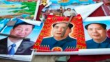 FILE - In this Feb. 5, 2015 file photo, vendors sell posters of Chinese President Xi Jinping, left, and Communist Party founder Mao Zedong, center and right, on a street of Gujiao in northern China's Shanxi province. 