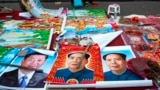 FILE - In this Feb. 5, 2015 file photo, vendors sell posters of Chinese President Xi Jinping, left, and Communist Party founder Mao Zedong, center and right, on a street of Gujiao in northern China's Shanxi province. 