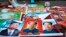 FILE - In this Feb. 5, 2015 file photo, vendors sell posters of Chinese President Xi Jinping, left, and Communist Party founder Mao Zedong, center and right, on a street of Gujiao in northern China's Shanxi province.