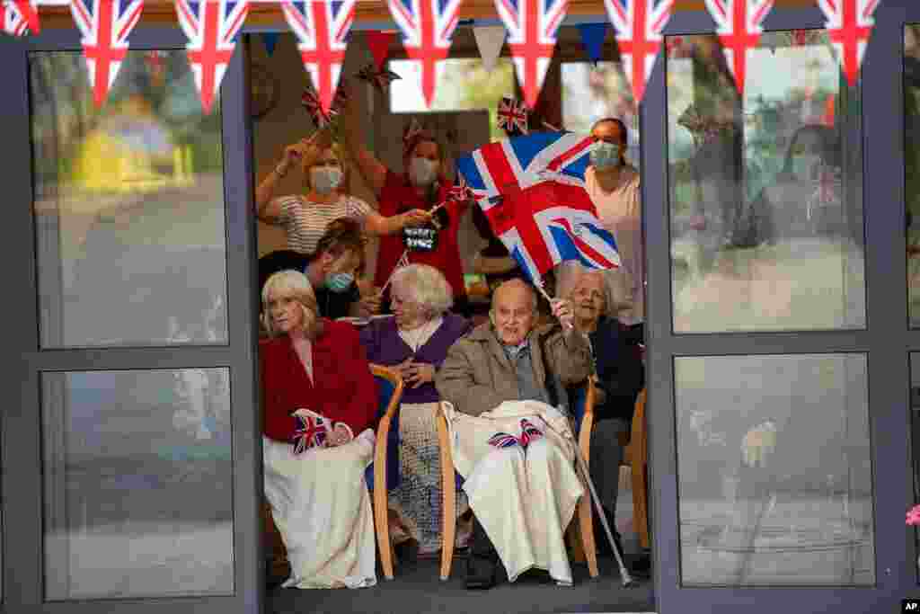 Residents wave to Britain's Prince William and Kate, Duchess of Cambridge, as they visit Cleeve Court Care Home in Bath, England, Dec. 8, 2020, on the final day of a three-day tour across the country.